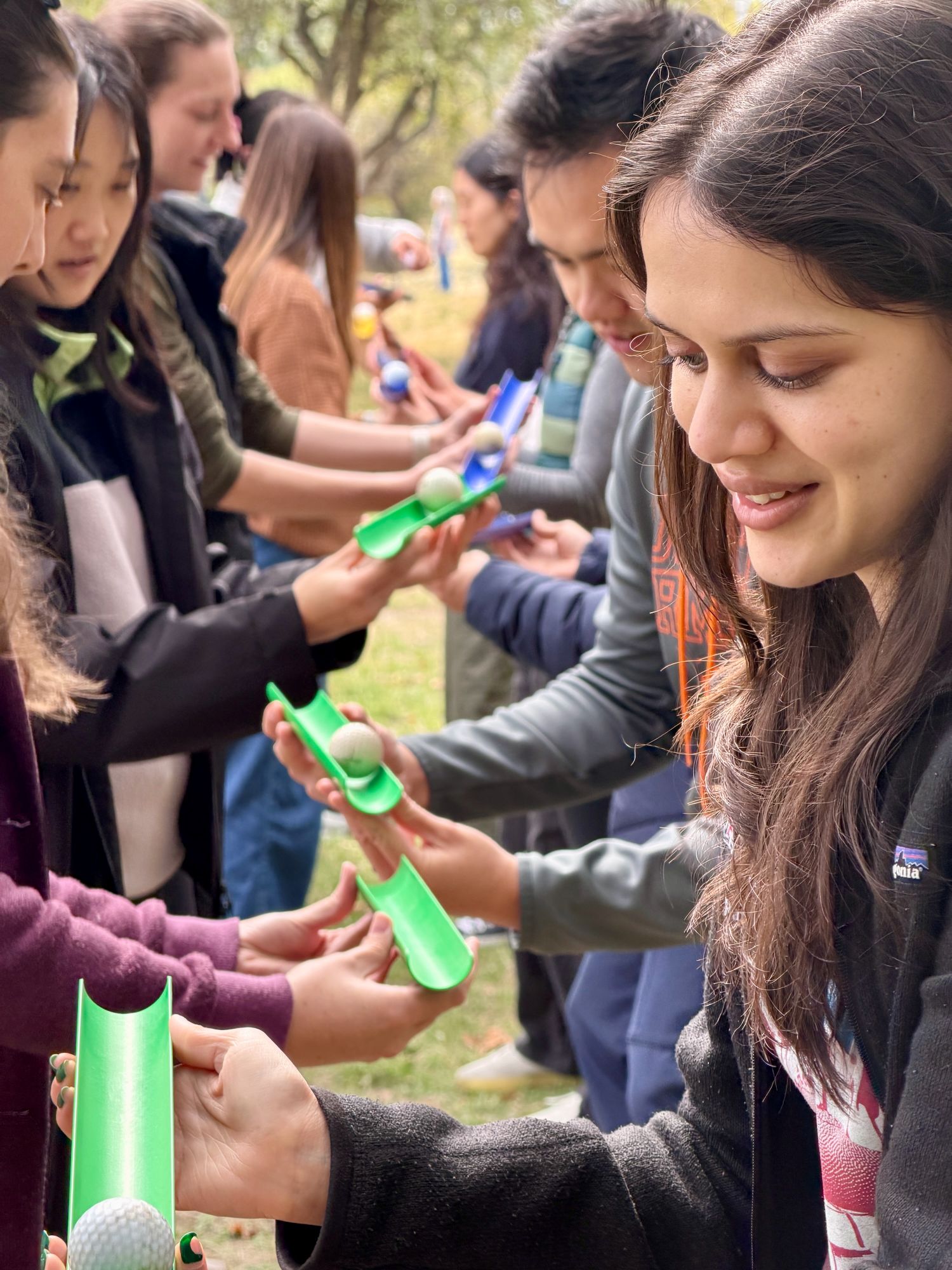 A closeup of people's faces as they participate in a team-building activity. 
