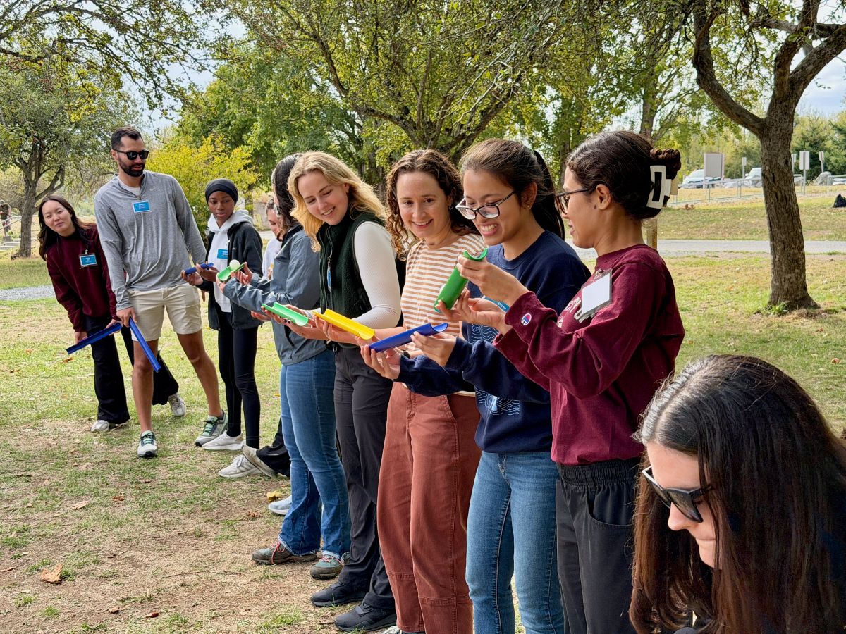 People stand in a line as they participate in a team building activity.