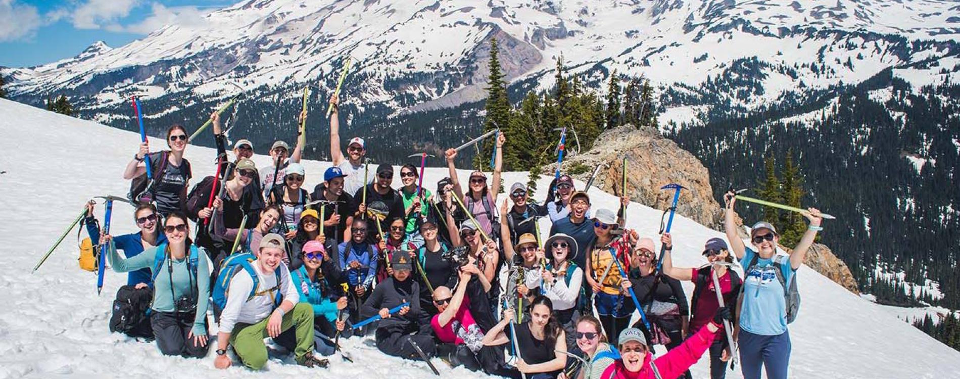 Large group of residents posing on a snowy mountain with ice picks